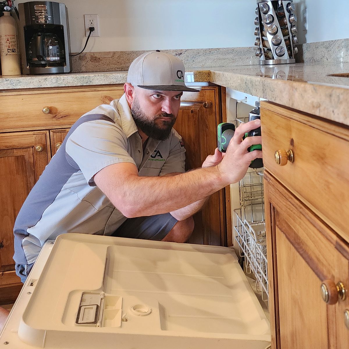 Cache Appliance technician repairing an open dishwasher