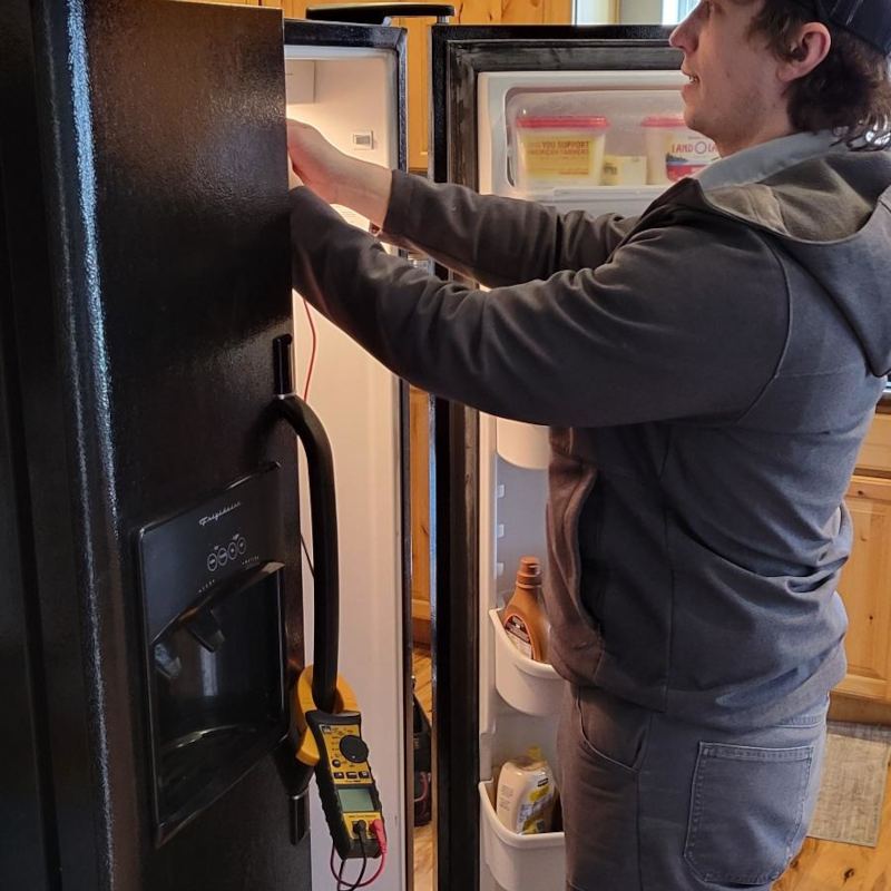Cache Appliance technician checking the fresh-food section of a side-by-side refrigerator