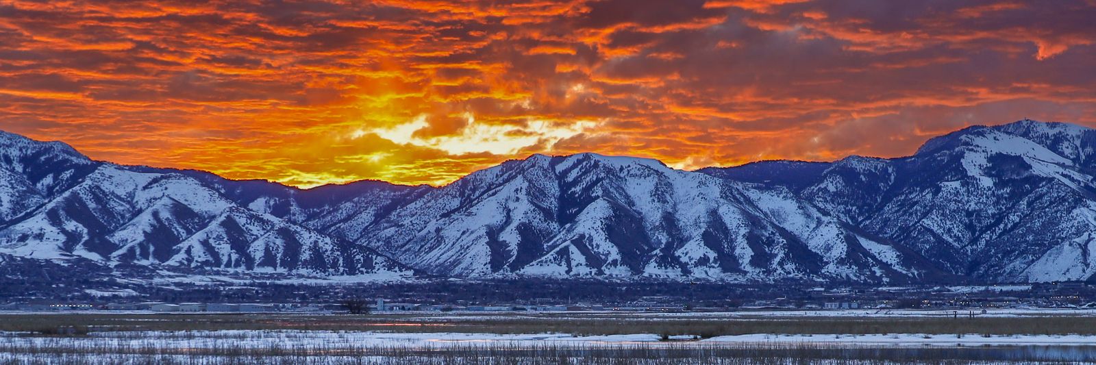 Snow-capped mountains above a northern Utah valley at sunset